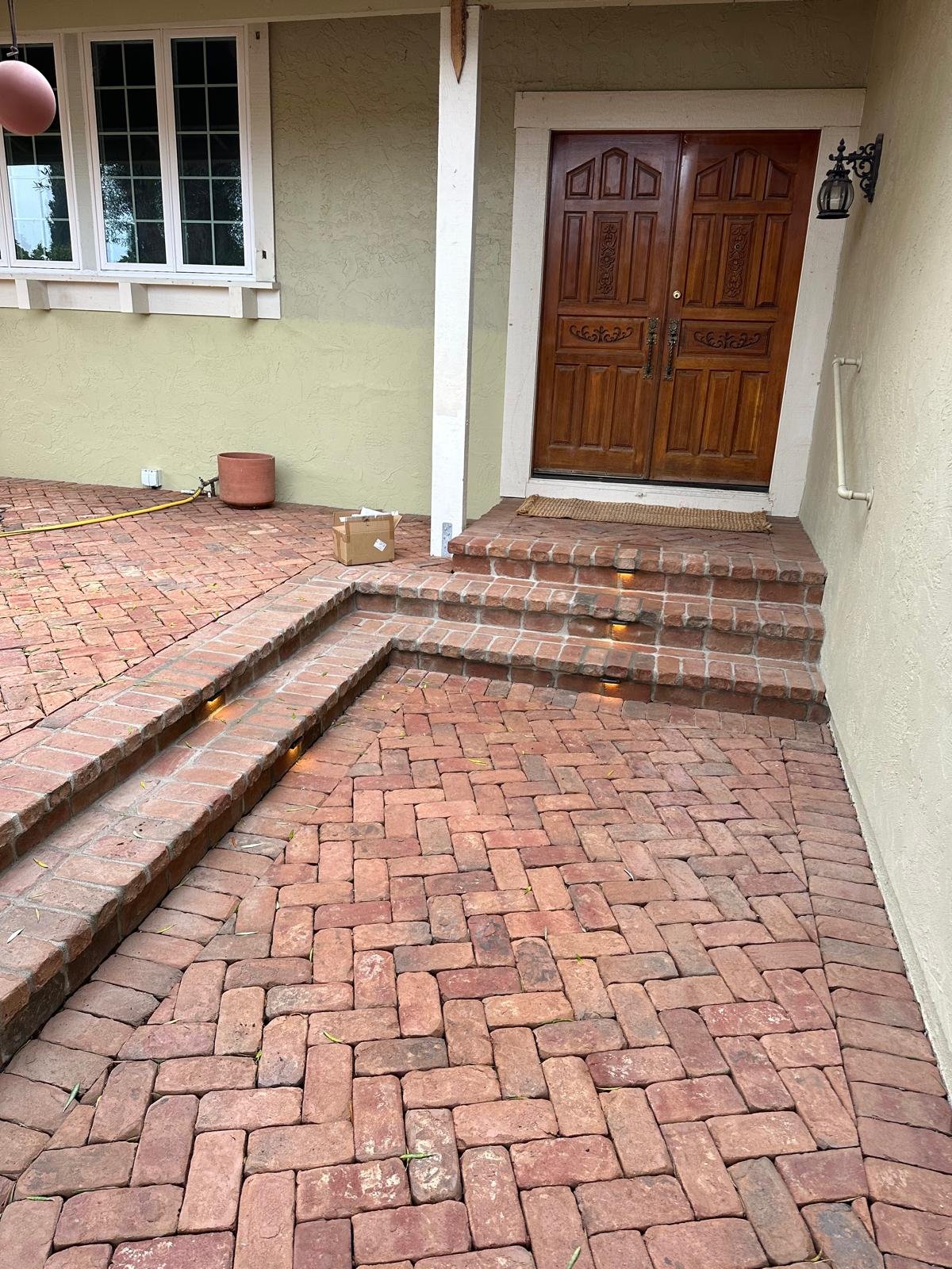 Herringbone brick entry landing with brick steps and built-in step lights